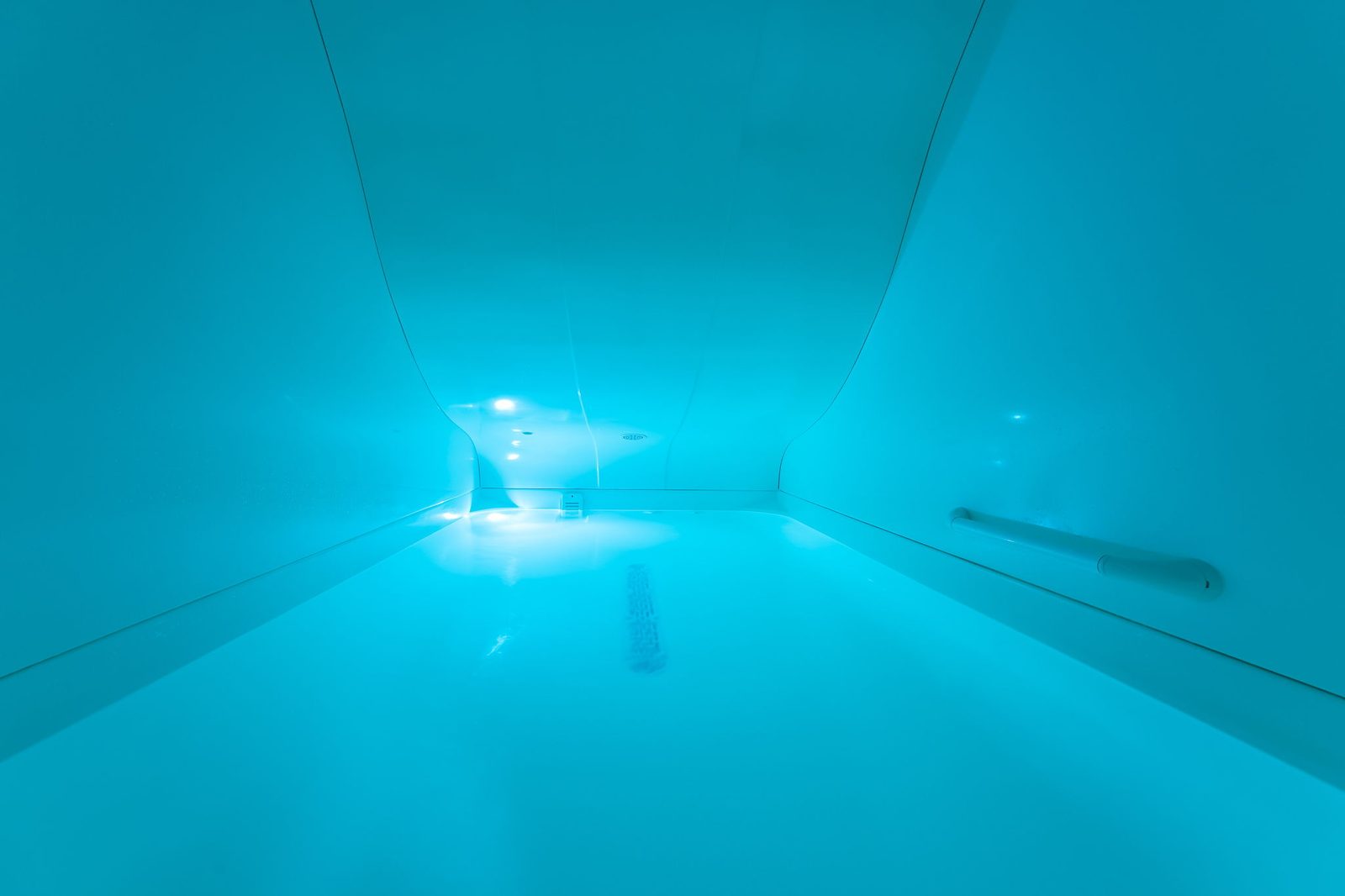 Salt room with float pod and glass-tile wall