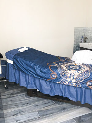 The facial room with a massage table and a sink